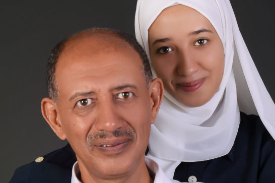 daughter and father standing close to one another in a photo studio stetting