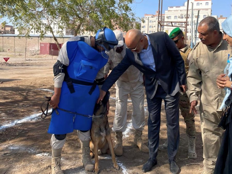 man caressing a dog in a demining centre