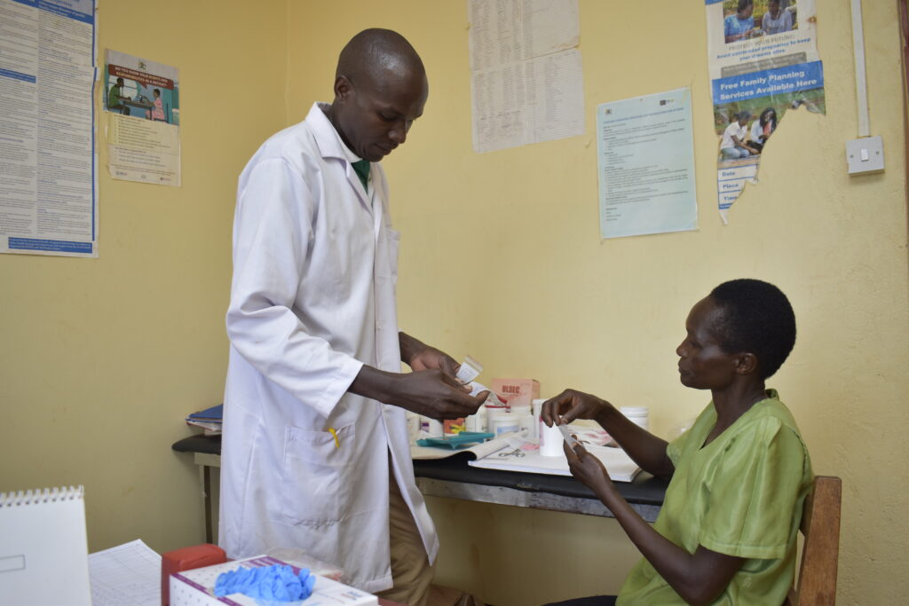 A nurse and a client in a Ugandan medical facility.