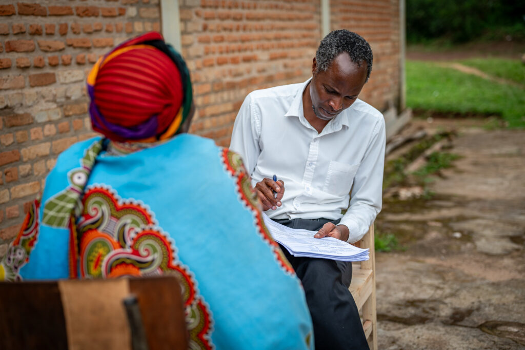 a man taking notes and a women sitting outside on chairs