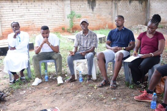 Kenyan youth in a circle meeting.