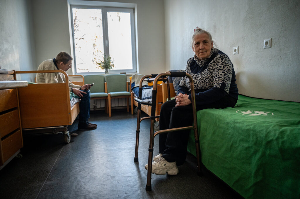 Elderly displaced Ukrainian woman and her son in a shelter location.