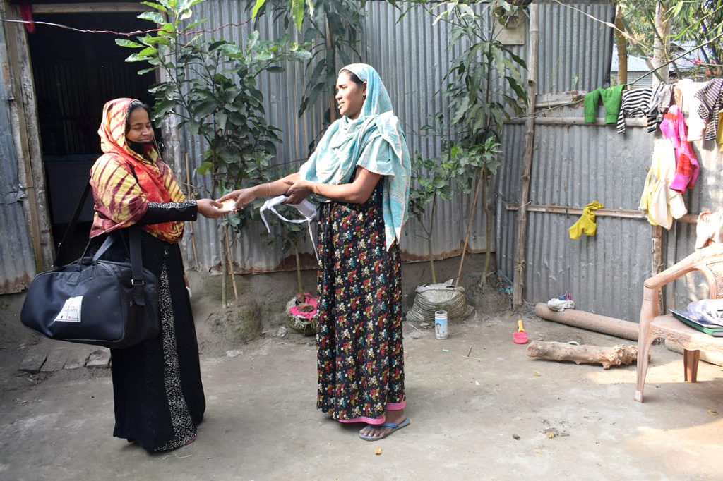 woman sells sanitary pads to a female customer in Gaibandha district
