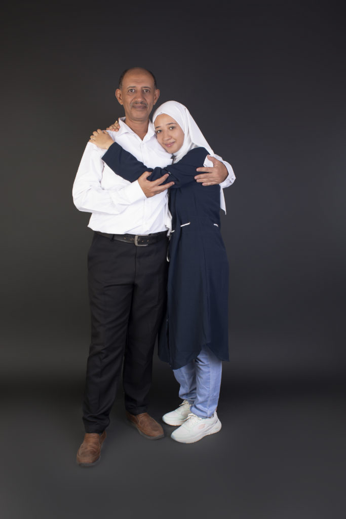 daughter and father standing close to one another in a photo studio stetting