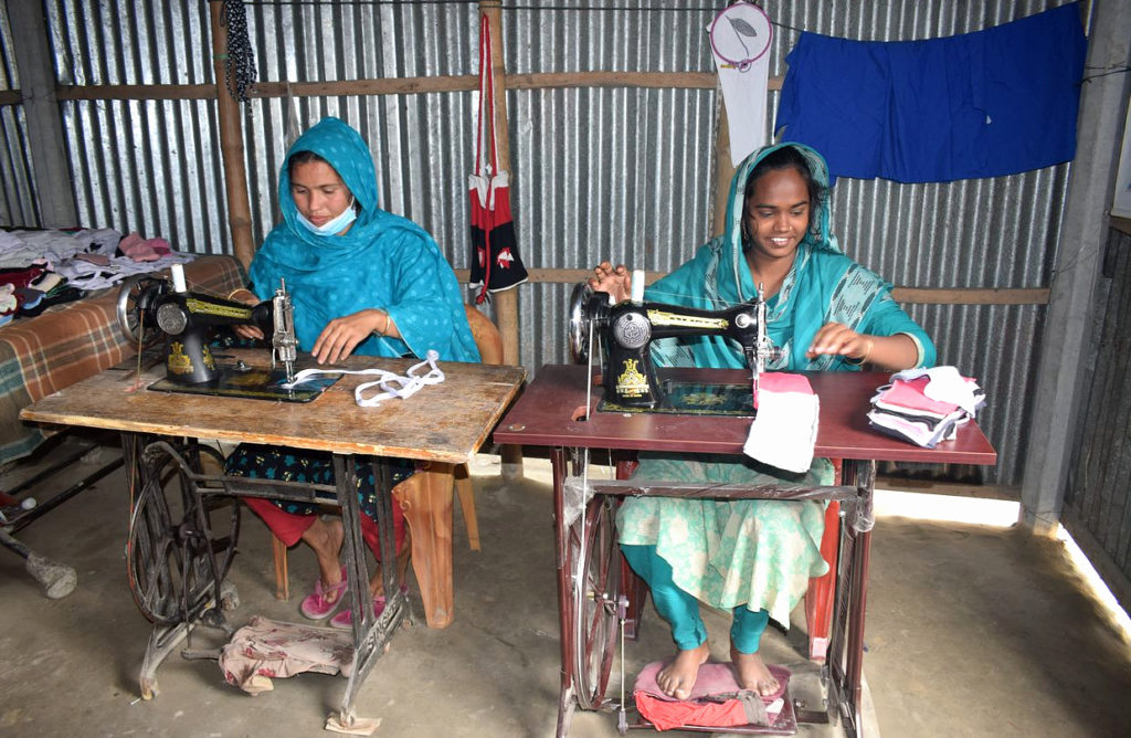 two young women sitting behind sewing machines produce eco-friendly and reusable sanitary padssanitary