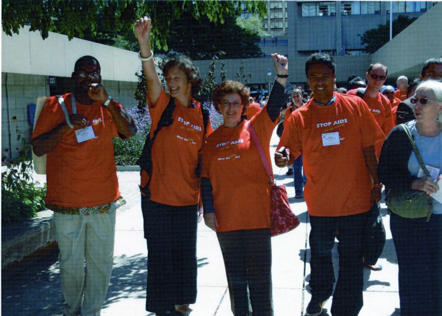 a group of people wearing orange shirts during a stop aids rally