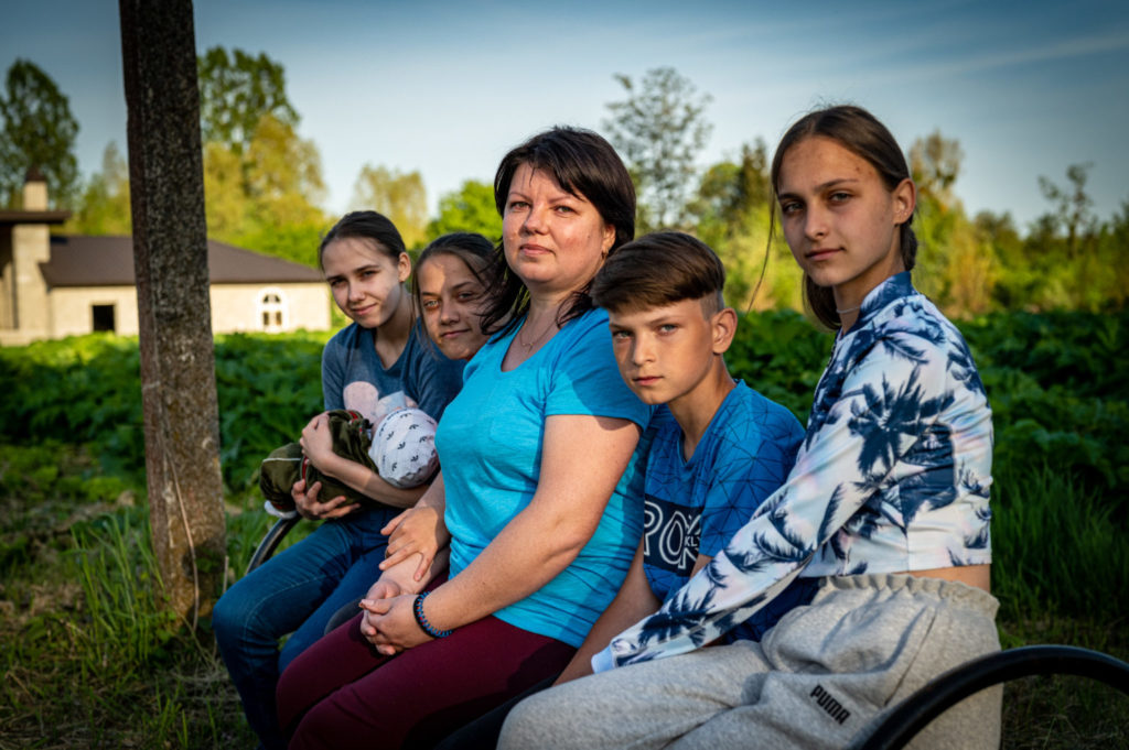 woman with four children sitting outside on a bench in agarden