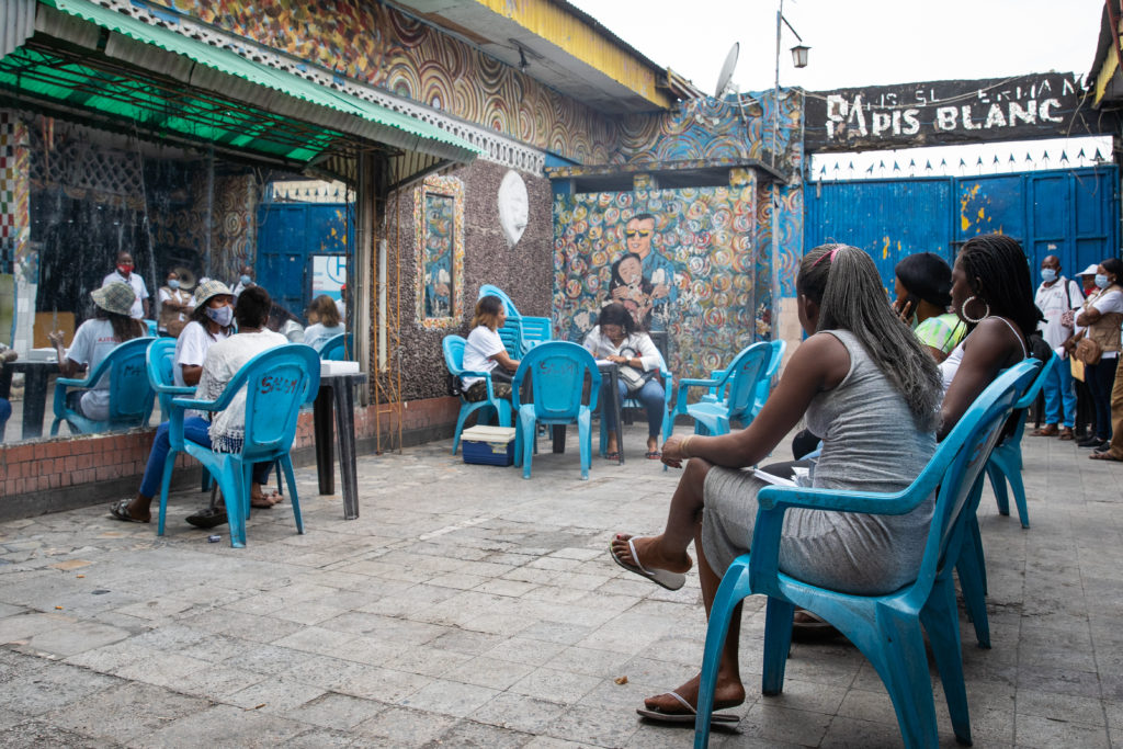 young women sitting on blue plastic chairs in the patio of a bar