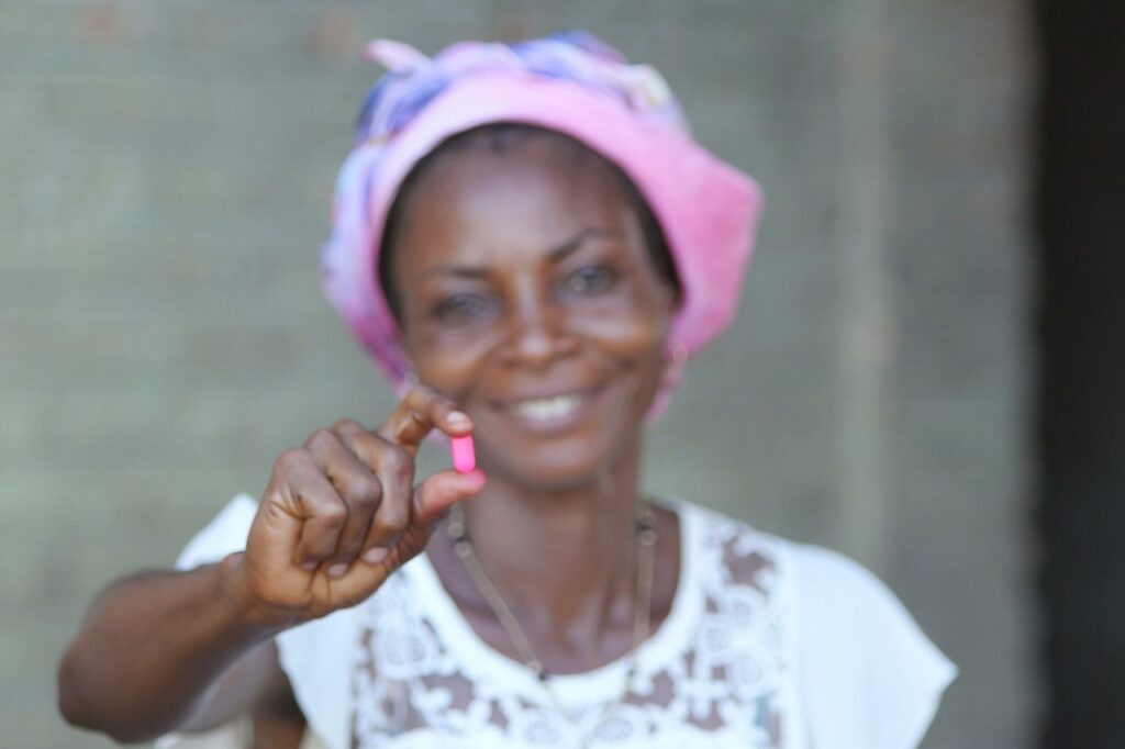 woman holding a single pill in her hand 