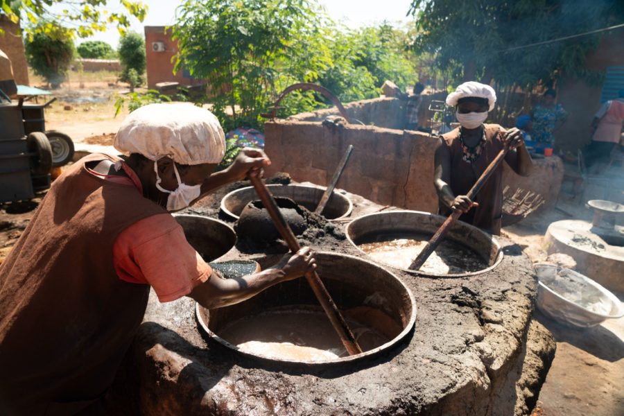 Two people working the Shea butter mixture