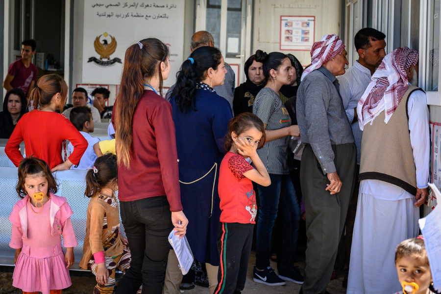 Children, men and women queue