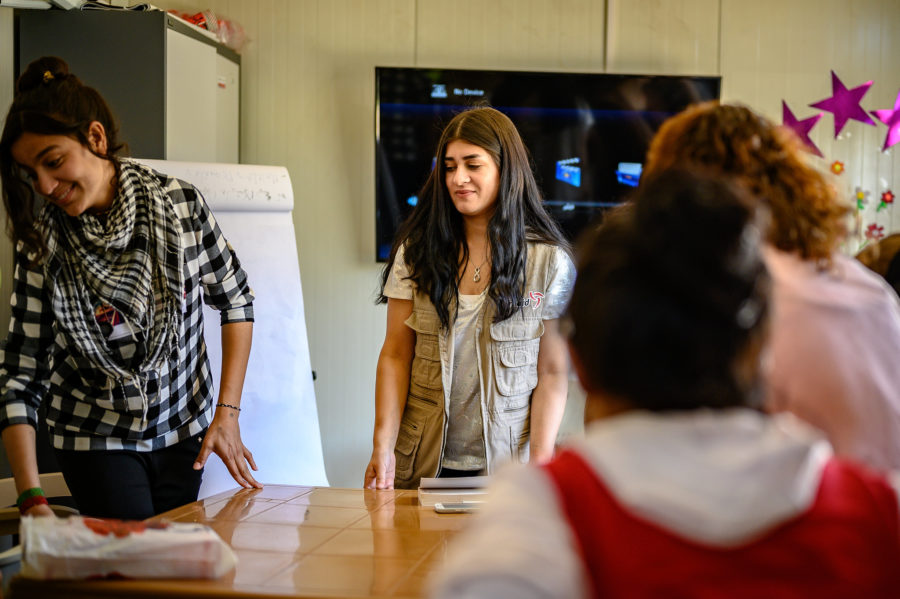 Women stand around a table during one of Sonita's awareness-raising sessions