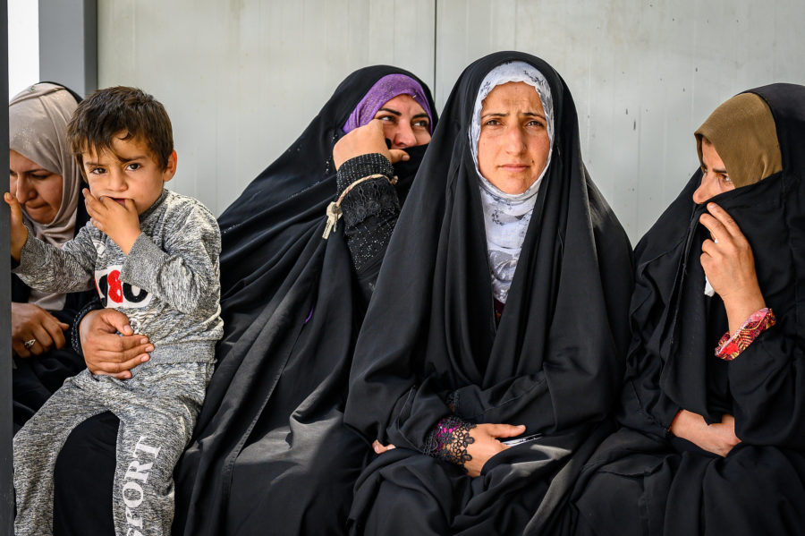 Four women and a young boy are pictured waiting for their Cordaid psychosocial session