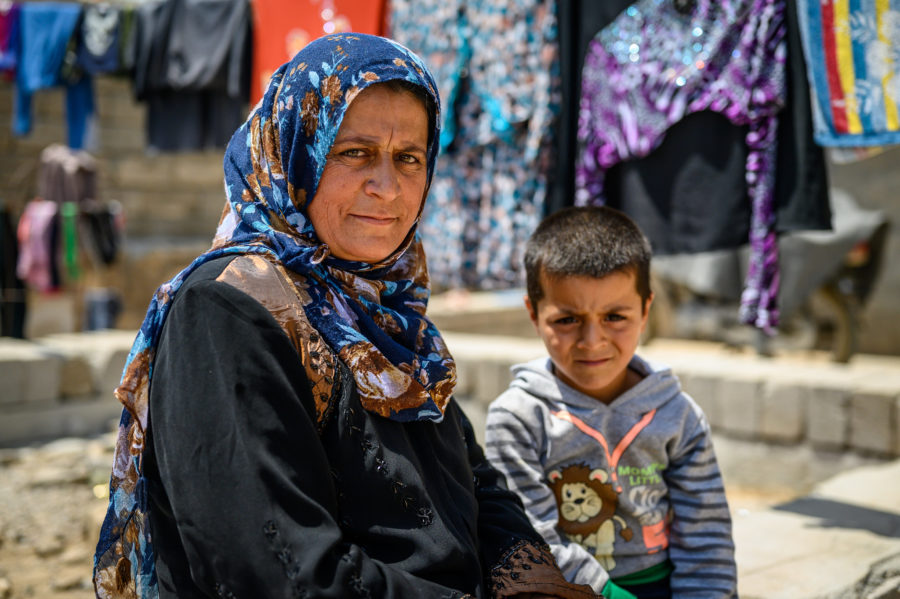 Wasila sat with her youngest son outside with clothes drying on a washing line in the background