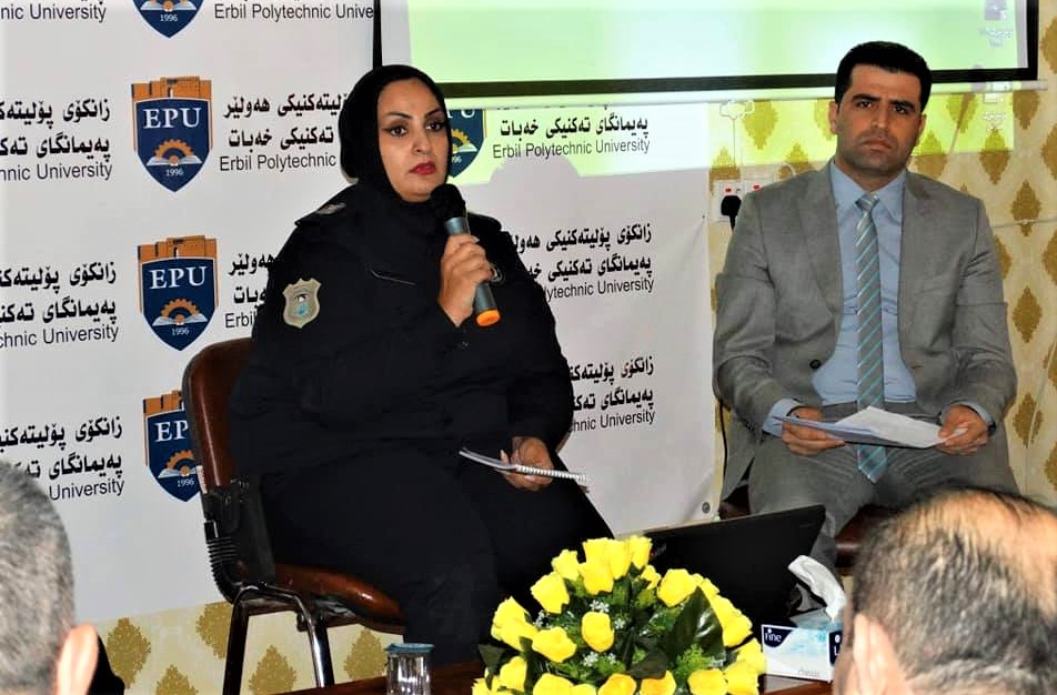 police officer and person in civilian clothes sitting in front of an audience